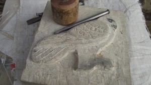 A block of stone with a carving of a bird in progress