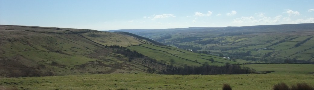 A sweeping landscape view with moorlands and valley sides
